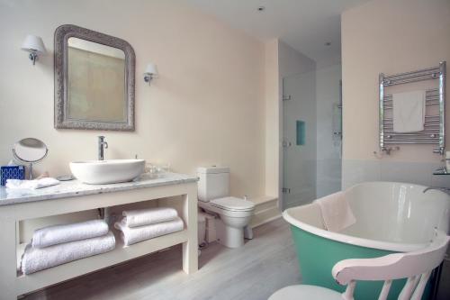 a bathroom with a tub and a sink and a toilet at Bear's Well Bed & Breakfast in Deal