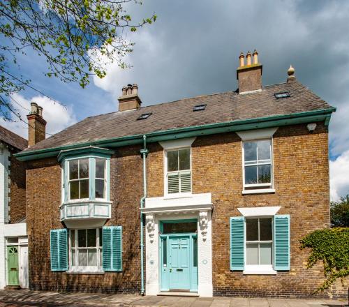 an old brick house with a blue door at Bear's Well Guest House in Deal