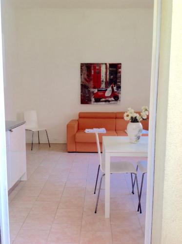 a living room with an orange couch and a table at Residence Villa Ofelia in Rimini
