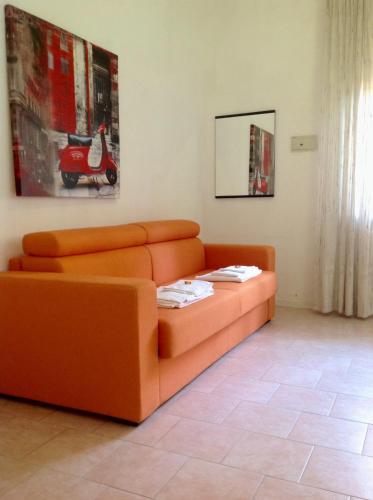 an orange couch sitting in a living room at Residence Villa Ofelia in Rimini