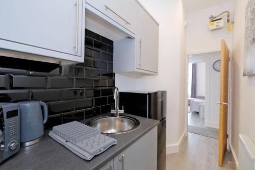 una pequeña cocina con fregadero y microondas en Orange Apartments Union Grove en Aberdeen