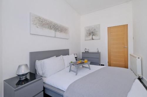 Un dormitorio con una cama con una mesa. en Orange Apartments Union Grove en Aberdeen