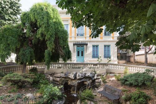 a building with a bench in front of a garden at Villa 216 in Lyon