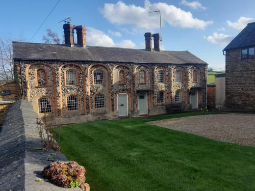 an old brick building with a yard in front of it at Bay Tree Cottage Accommodation in Farthingstone