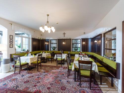 a restaurant with tables and chairs in a room at Landhaus Margarethe in Hopfgarten im Brixental