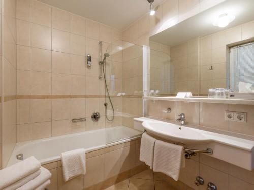 a bathroom with a tub and a sink and a shower at Landhaus Margarethe in Hopfgarten im Brixental