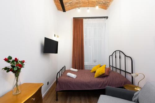 um quarto com uma cama com almofadas amarelas em Ceglane Sufity em Cracóvia
