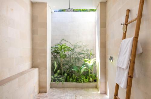 a bathroom with a shower with a mural of plants at Villa Mia in Canggu