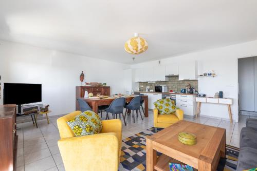 Il comprend un salon avec des chaises jaunes et une cuisine. dans l'établissement L'Airelle, à Saint-Malo