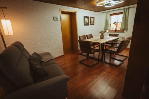 een woonkamer met een bank en een tafel en stoelen bij FERIENPARADIES AM KAMMERBERG - ein ganzes Haus für Sie alleine!!! in Weißenhorn
