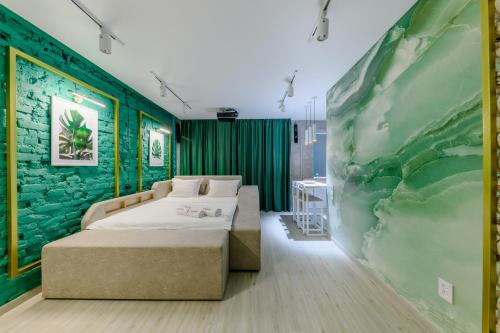 1 dormitorio con 2 camas y pared verde en Квартира-студия c домашним кинотеатром Ocean, en Petropavlovsk