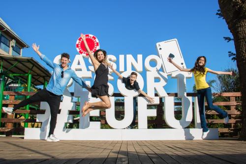 a group of people jumping in the air in front of a sign at Cassino All Inclusive Resort Poços de Caldas By Nacional Inn in Poços de Caldas