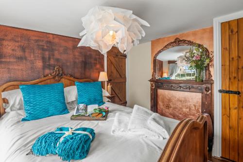 a bedroom with a bed with blue pillows and a chandelier at Cramwell in Exeter