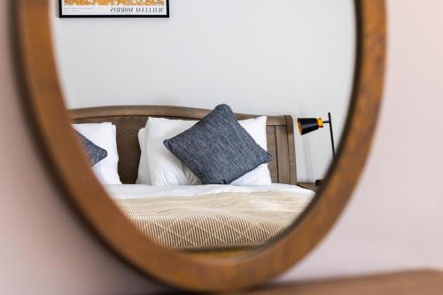 a mirror reflecting a bed in a bedroom at The Unicorn (Apartments) in Stow on the Wold