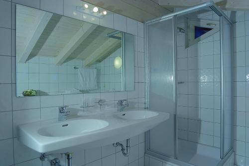 ein weißes Bad mit 2 Waschbecken und einer Dusche in der Unterkunft Appartement Chalet Claudia in Mittersill