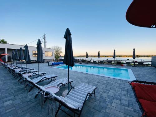 a swimming pool with chairs and umbrellas and a pool at Casa Mina Divici in Divici