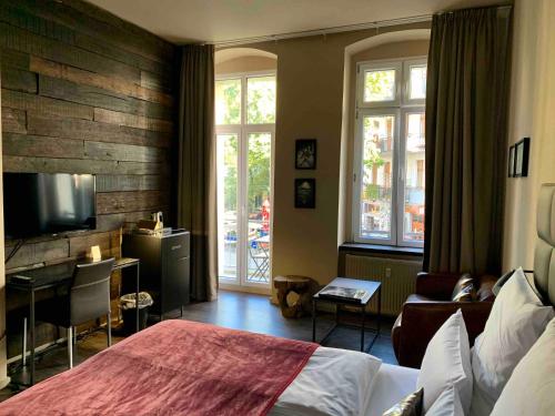 Habitación de hotel con cama, escritorio y TV. en Arbio I Apartmently Studios & Apartments en Berlín