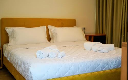 a bed with four rolled up towels on it at Bujtina Adora 