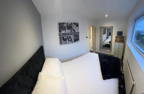 a small bedroom with a white bed and a window at House Sleeps 8. 2bedrooms & sofa beds in sitting room in Bath