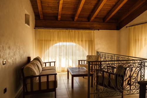 a living room with a couch and a window at Tenuta Un Posto Al Sole Luxury B&B in Rossano Stazione