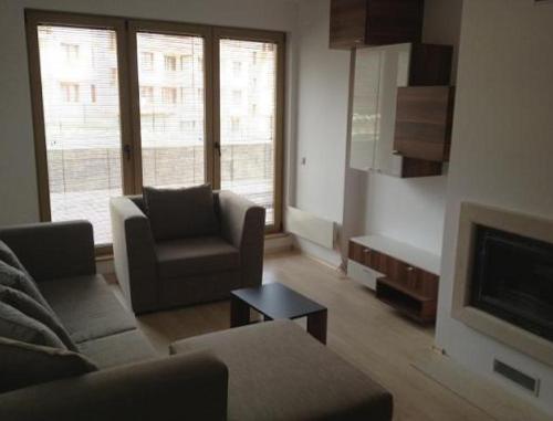 バンスコにあるRoy's Apartment in St John Parkのリビングルーム(ソファ、椅子、テレビ付)