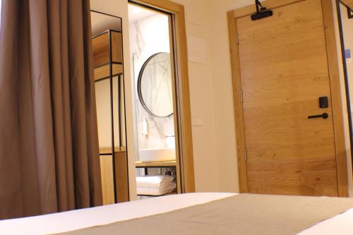 a bedroom with a wooden door and a mirror at Hotel Marfany in Andorra la Vella