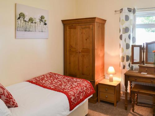 um quarto com uma cama, uma cómoda e uma secretária em The Racecourse Lodge em Hexham