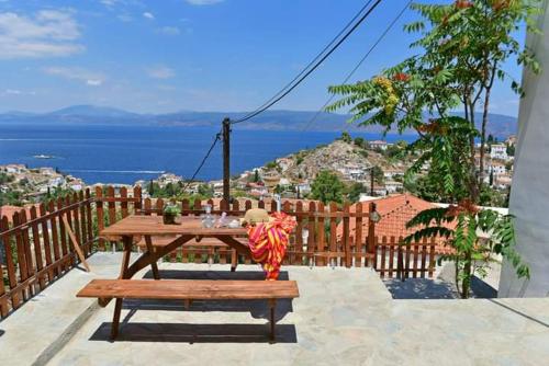a picnic table on a balcony with a view of the ocean at Haven in Hydra
