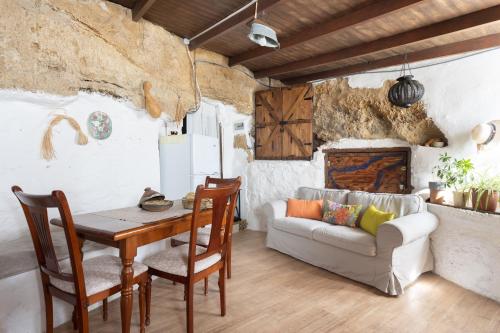 sala de estar con mesa y sofá en Casa Cueva Gaspara, en Lomo de Arico