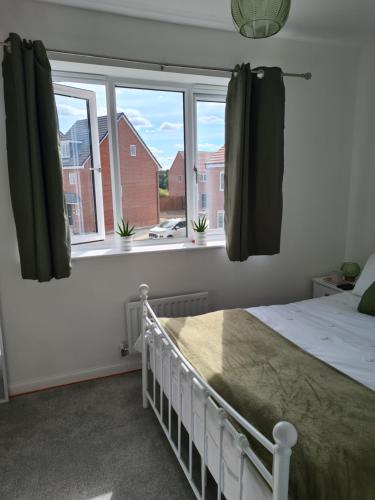 a bedroom with a bed and two windows at Ria's B n B in Pocklington