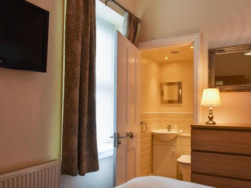a bedroom with a bathroom with a sink and a toilet at End Cottage in Alnwick