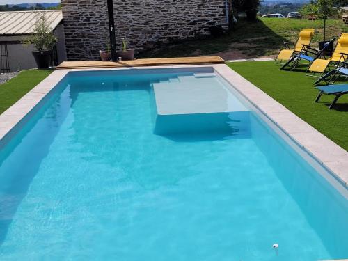 een zwembad met blauw water in een tuin bij Tout au bout du chemin in Réquista