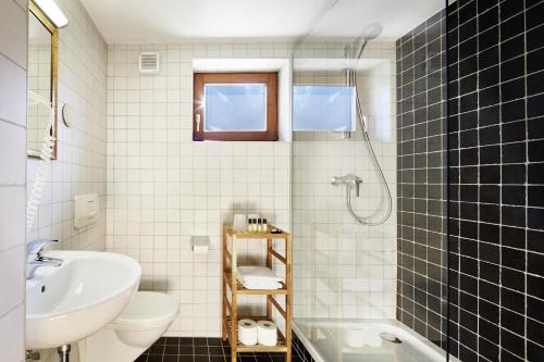 a bathroom with a sink and a toilet and a shower at Gästehaus Huber in Mayrhofen