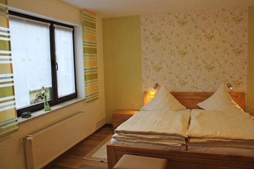 Schlafzimmer mit einem Bett und einem Fenster in der Unterkunft Haus Hesseberg in Medebach