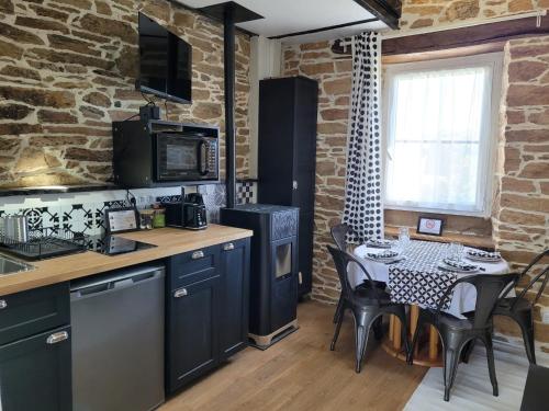 a kitchen and dining room with a table and chairs at Tout au bout du chemin in Réquista