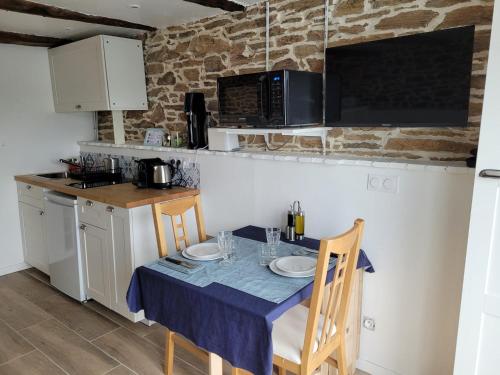 a kitchen with a table with two plates on it at Tout au bout du chemin in Réquista