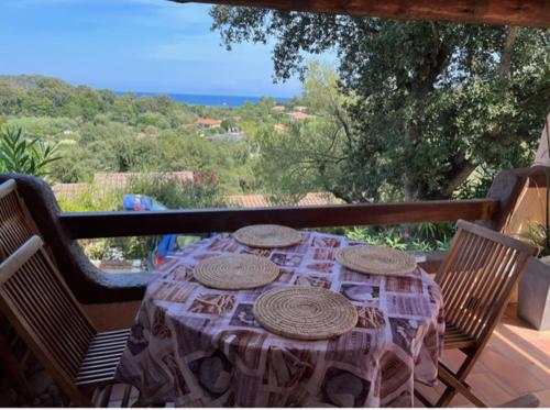 a table with plates on top of a balcony at Mini Villa St-Lucie Porto-Vecchio vue mer 5mnplage in Zonza