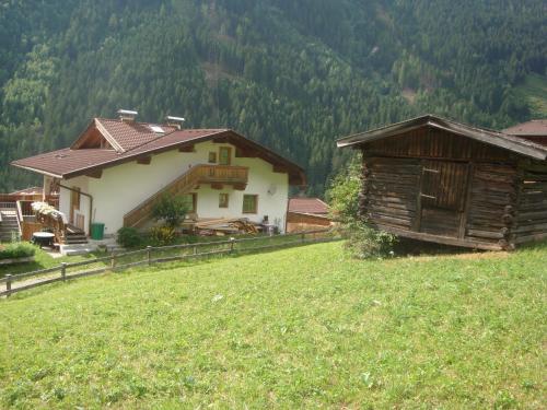 a house on top of a hill with a grass field at Alpenhaus Christian in Neustift im Stubaital