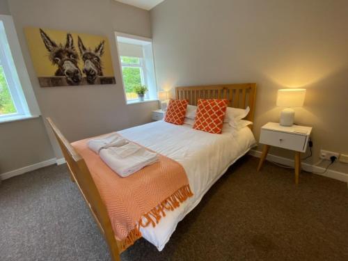 a bedroom with a large bed with orange and white sheets at South Lodge - Uk31880 in Newton Stewart