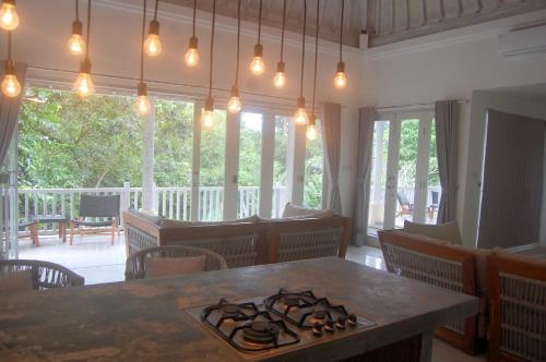 a dining room with a table with a stove at Balian Bliss Retreat Bungalow & Villas in Balian
