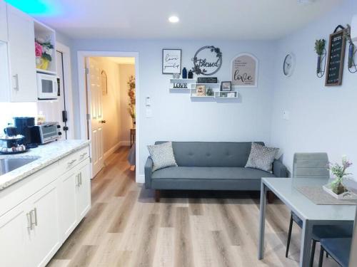 a living room with a blue couch and a kitchen at Torres Tiny Home Midtown WestTampa RJS in Tampa