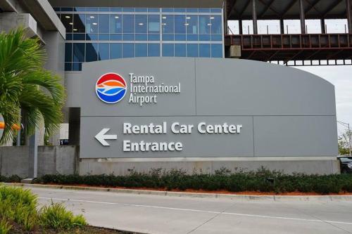 una señal para un centro de alquiler de coches frente a un edificio en Torres Tiny Home Midtown WestTampa RJS en Tampa