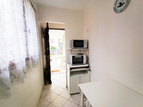 Cette petite chambre dispose d'un four micro-ondes et d'une télévision. dans l'établissement Charmant T2 en RDC avec Jardin, Quartier Calme à Aix-les-Bains - FR-1-555-41, à Aix-les-Bains