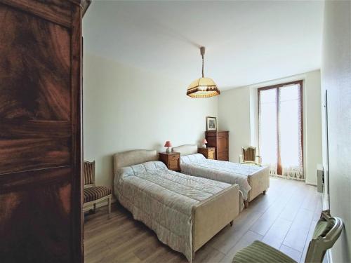 een slaapkamer met 2 bedden en een groot raam bij Appartement Aix-les-Bains, 2 pièces, 2 personnes - FR-1-555-48 in Aix-les-Bains