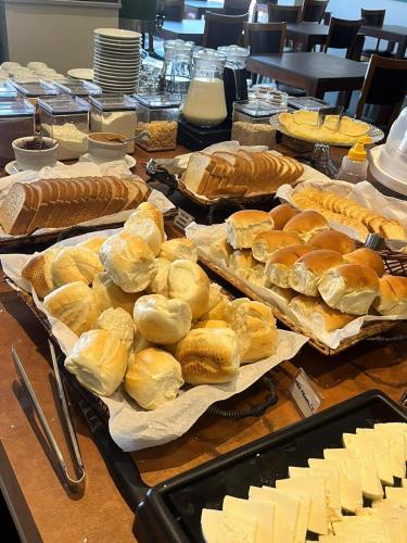 a table topped with lots of bread and cheese at ibis Styles Presidente Prudente Portal D'Oeste in Presidente Prudente