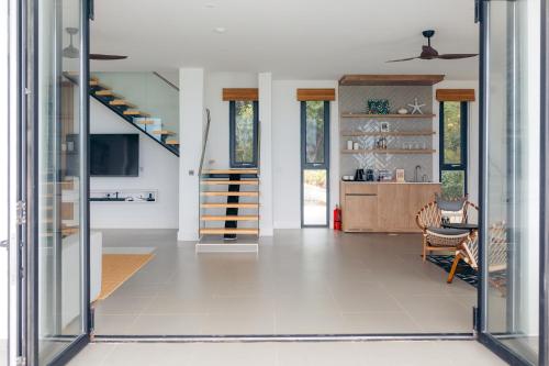 a living room with a staircase in a house at Safira Blu Luxury Resort & Villas in Nungwi