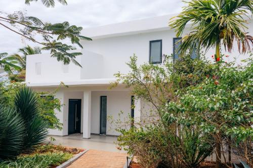 a white house with trees in front of it at Safira Blu Luxury Resort & Villas in Nungwi