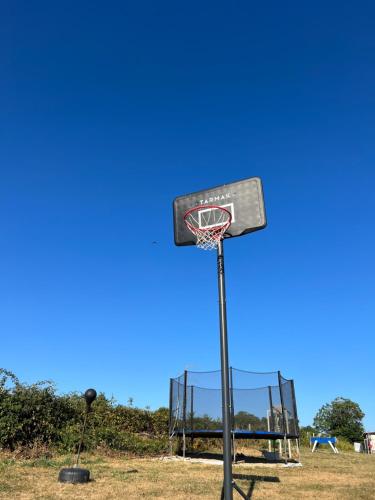 a basketball hoop in a field with a blue sky at Tout au bout du chemin in Réquista