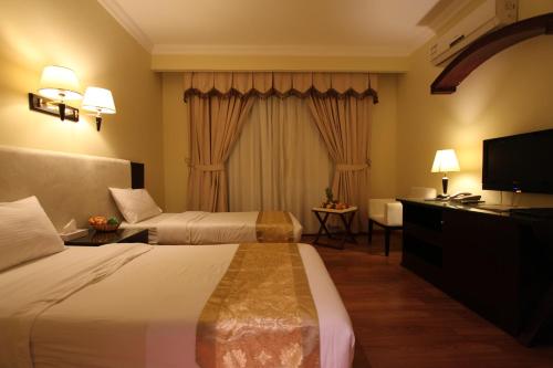 En eller flere senge i et værelse på Al Maha Residence Rak