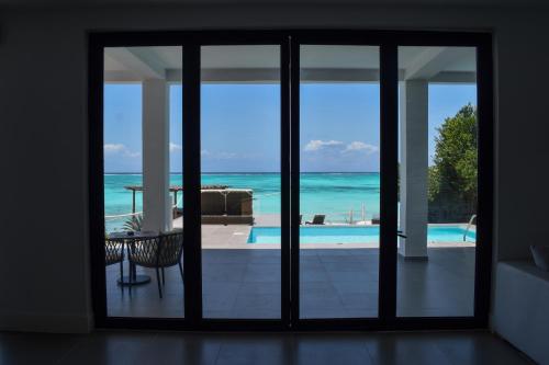 a room with a view of the ocean from a house at Safira Blu Luxury Resort & Villas in Nungwi